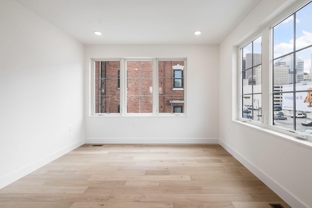 empty room with visible vents, recessed lighting, light wood-style flooring, and baseboards