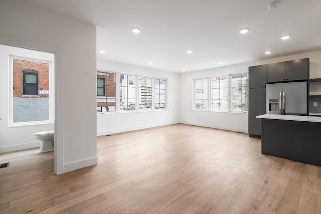 unfurnished living room featuring visible vents, baseboards, light wood-style flooring, and recessed lighting