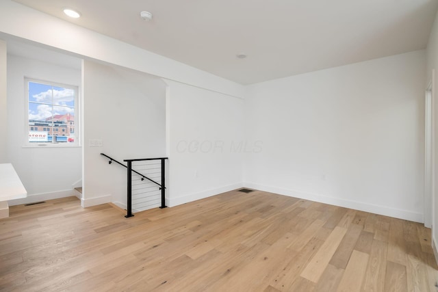 empty room featuring recessed lighting, baseboards, visible vents, and light wood finished floors