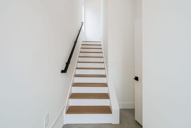 staircase featuring concrete flooring