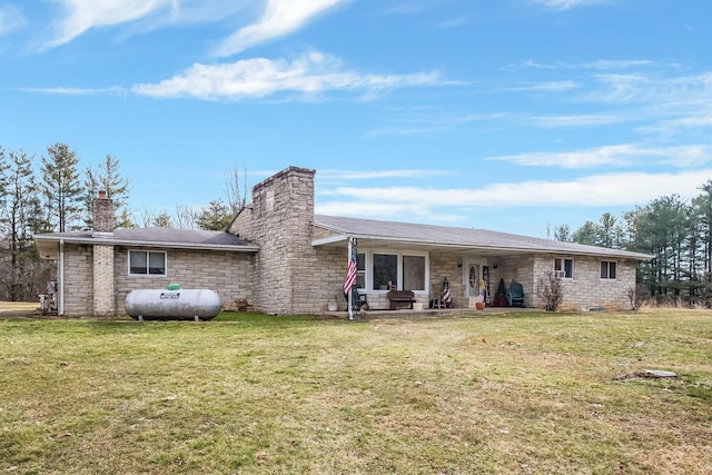 back of property featuring a chimney and a lawn