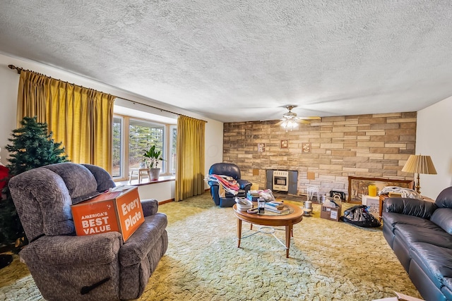 living area featuring light carpet, ceiling fan, and a textured ceiling