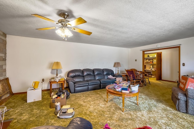 carpeted living room featuring ceiling fan, baseboards, and a textured ceiling