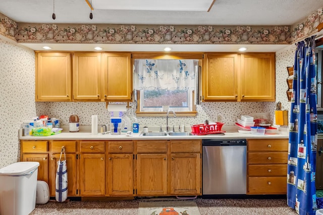 kitchen with light countertops, stainless steel dishwasher, brown cabinetry, a sink, and wallpapered walls