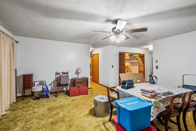 carpeted office space with a textured ceiling and a ceiling fan