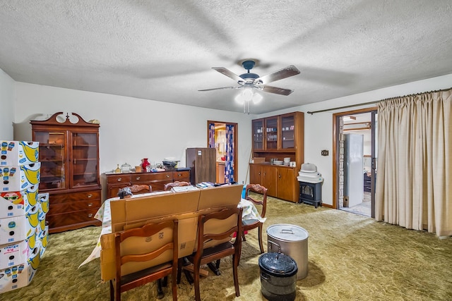 dining room featuring carpet floors, ceiling fan, and a textured ceiling