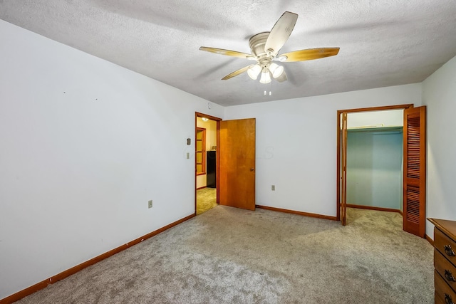 unfurnished bedroom with carpet floors, ceiling fan, a textured ceiling, and baseboards