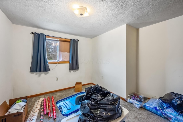 carpeted bedroom with a textured ceiling and baseboards