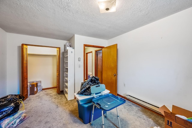 carpeted bedroom featuring baseboards, a textured ceiling, a baseboard heating unit, and a closet