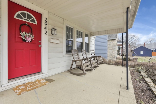 property entrance featuring stone siding and a porch