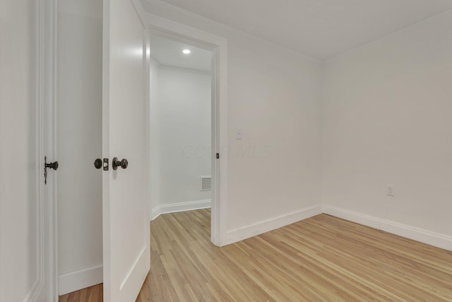 spare room featuring baseboards and light wood-style floors