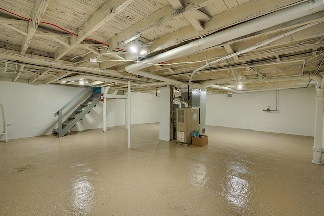 unfinished basement with stairs and heating unit