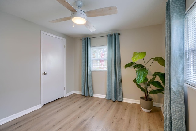 spare room with a ceiling fan, baseboards, and wood finished floors