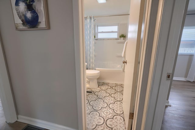 bathroom with shower / bath combo, baseboards, visible vents, toilet, and tile patterned flooring