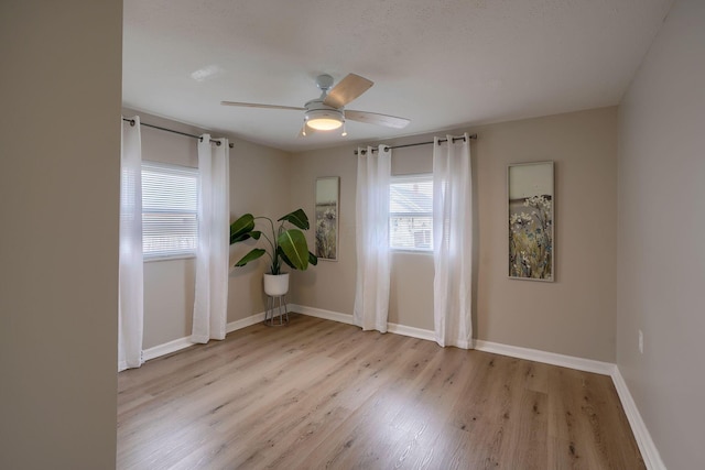 spare room with baseboards, a ceiling fan, and wood finished floors