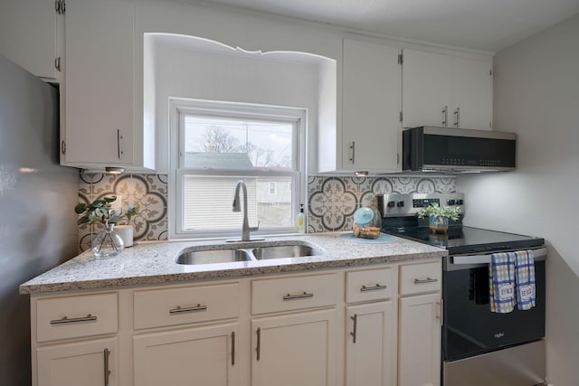 kitchen with stainless steel appliances, white cabinetry, a sink, and backsplash