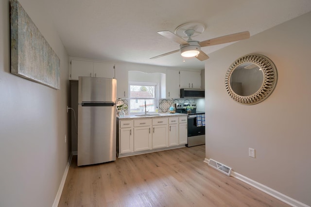 kitchen with stainless steel appliances, light wood-style flooring, visible vents, and white cabinetry