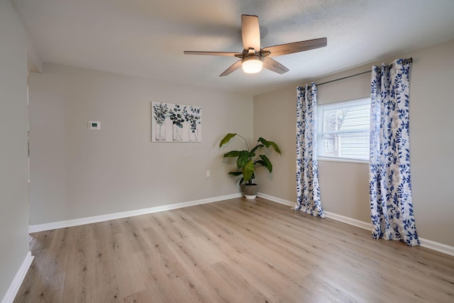 spare room with ceiling fan, baseboards, and wood finished floors