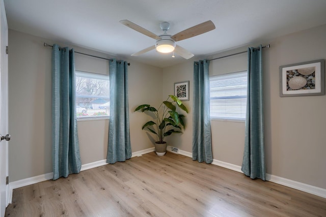 unfurnished room featuring a healthy amount of sunlight, light wood finished floors, baseboards, and a ceiling fan