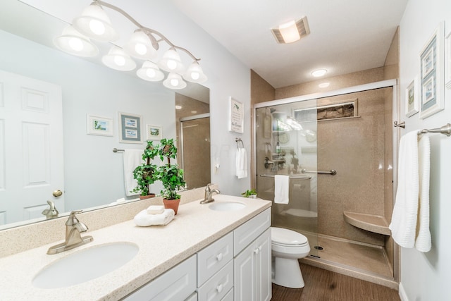 bathroom with visible vents, a sink, toilet, and a shower stall