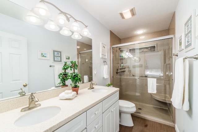 bathroom featuring toilet, a shower stall, visible vents, and a sink