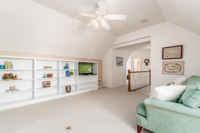 living area with light carpet, visible vents, an upstairs landing, vaulted ceiling, and a ceiling fan