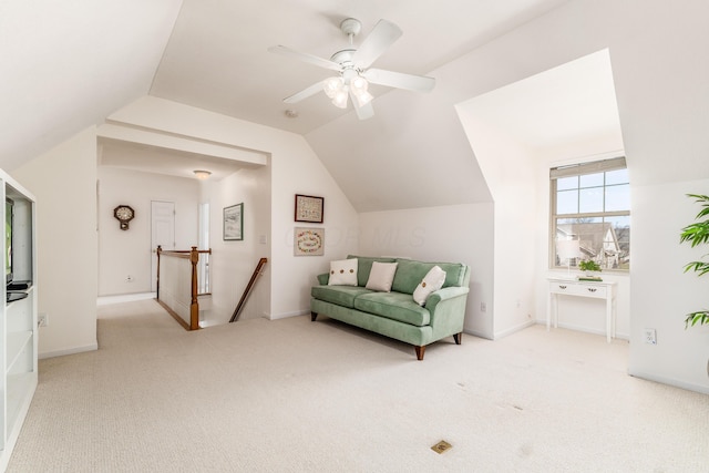 living area with carpet floors, lofted ceiling, baseboards, and an upstairs landing