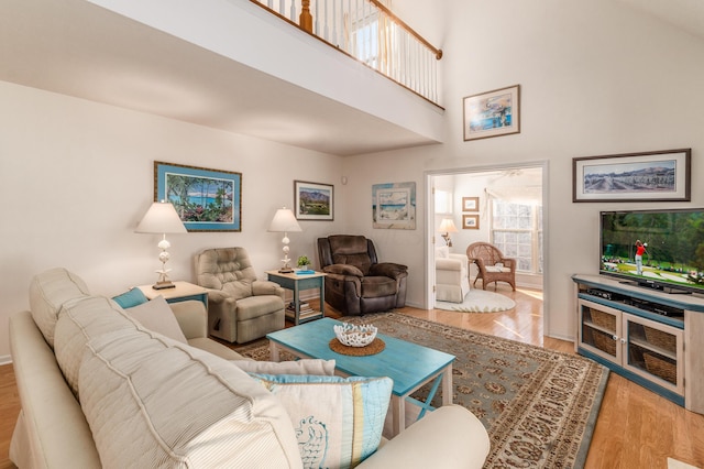 living area with a high ceiling and wood finished floors