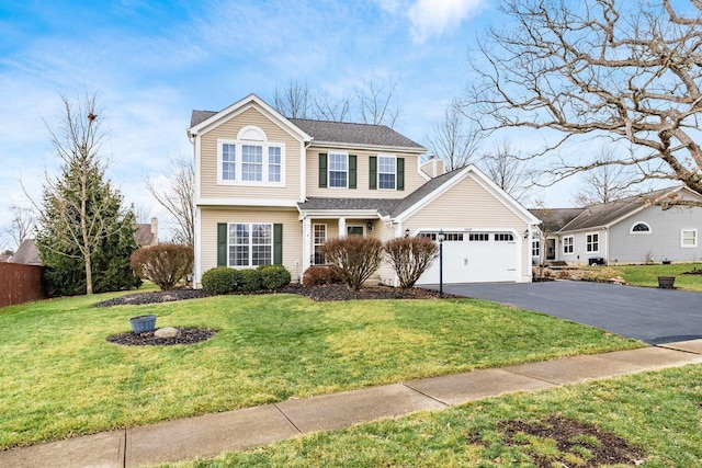 traditional home with driveway, a garage, and a front yard