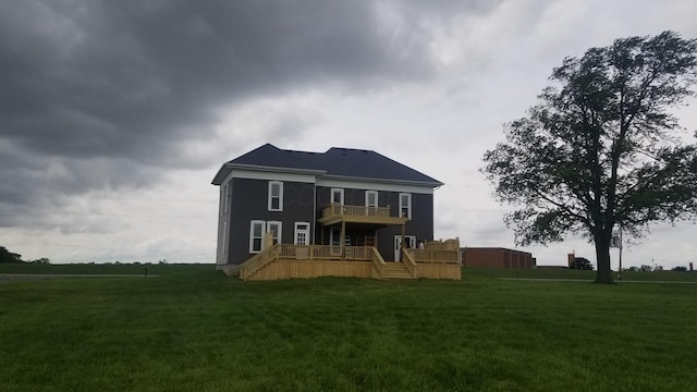 rear view of property with a yard, stairway, and a wooden deck