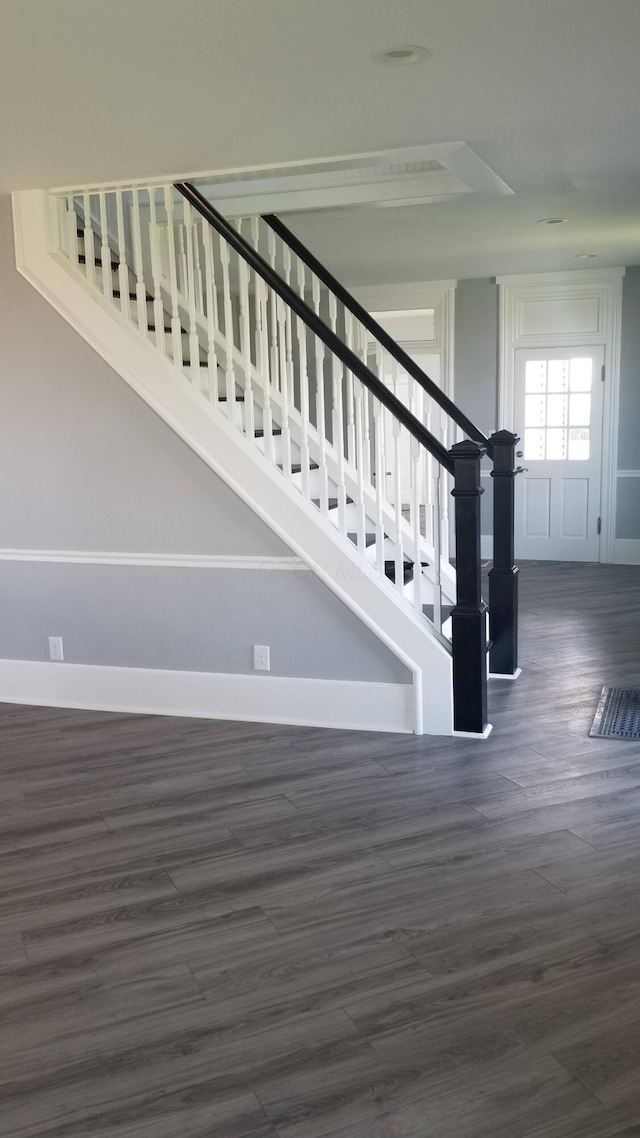 staircase featuring baseboards and wood finished floors