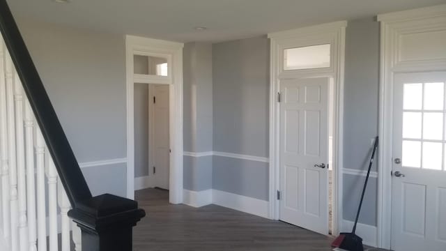 corridor featuring dark wood-style floors, stairs, and baseboards