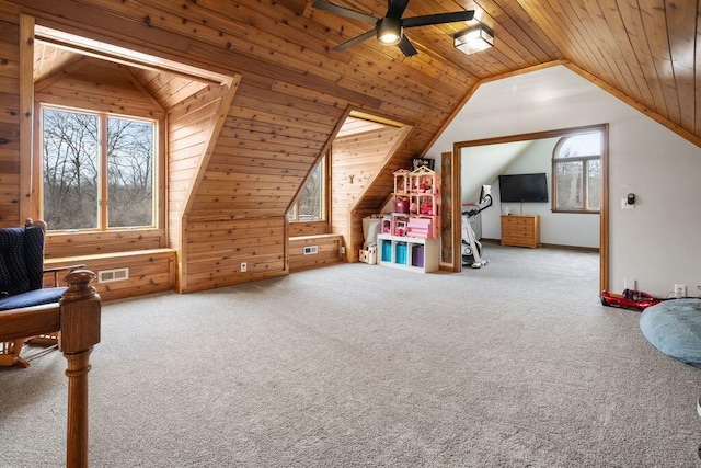 additional living space with carpet, wooden ceiling, visible vents, and wooden walls