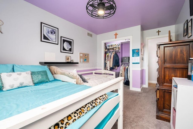 bedroom featuring a walk in closet, a closet, light colored carpet, visible vents, and baseboards