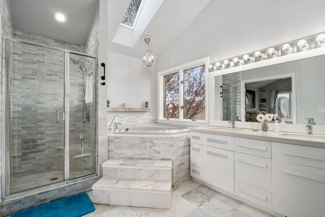 bathroom featuring vaulted ceiling with skylight, double vanity, a sink, and a bath