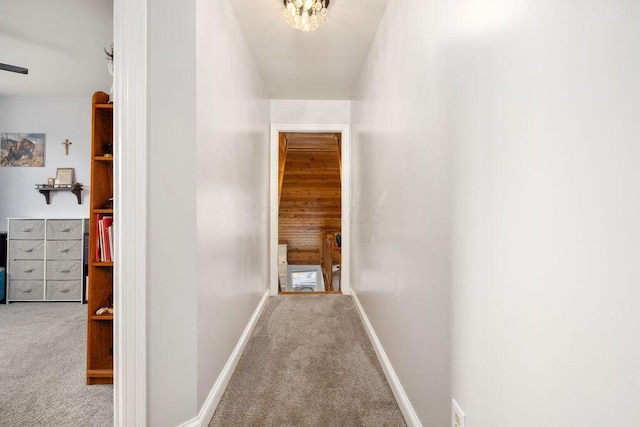 hallway featuring light carpet and baseboards