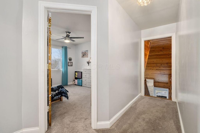 hall with baseboards, light carpet, and an upstairs landing