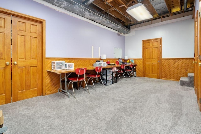 office space featuring carpet, wood walls, and wainscoting