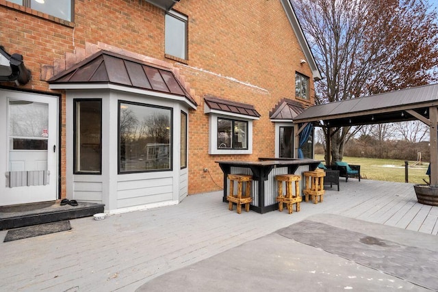 view of patio / terrace with outdoor dry bar, a gazebo, and a wooden deck