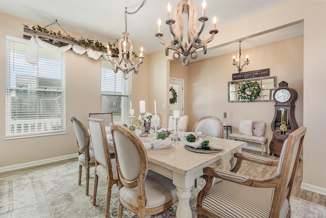 dining area with a chandelier, light wood-style flooring, and baseboards