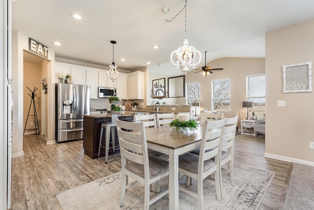 dining room featuring lofted ceiling, ceiling fan, recessed lighting, baseboards, and light wood-style floors