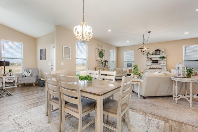 dining room with a chandelier, lofted ceiling, light wood finished floors, and recessed lighting