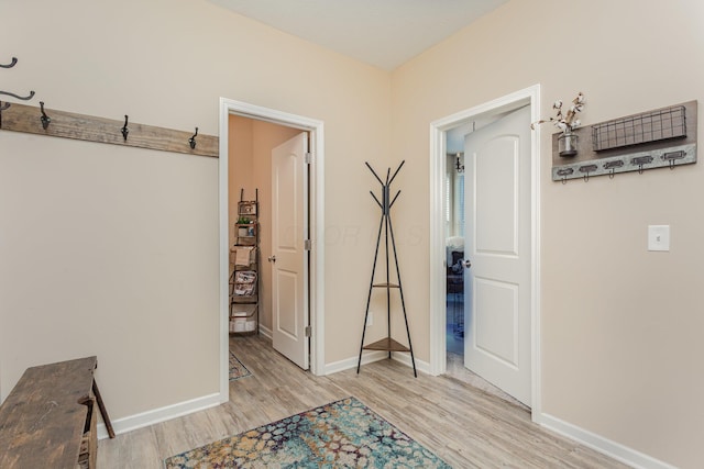 hallway with light wood-type flooring and baseboards