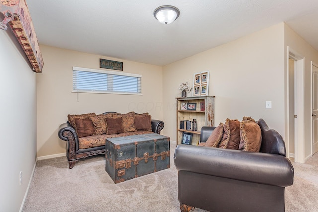 living area featuring light carpet and baseboards