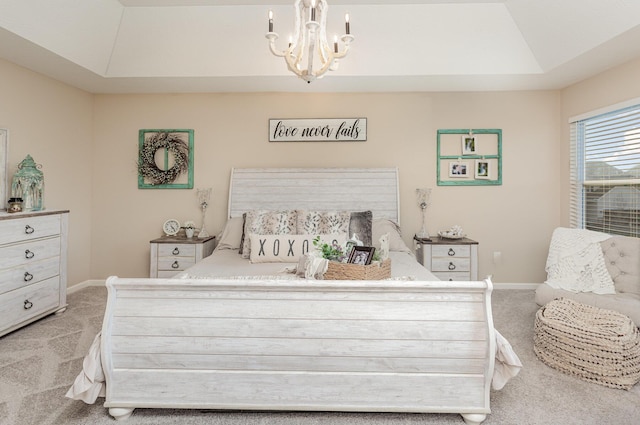 bedroom with an inviting chandelier, baseboards, a tray ceiling, and light colored carpet