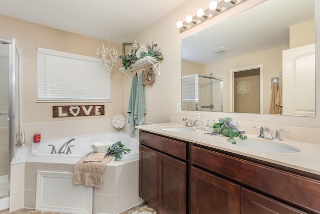 full bathroom with double vanity, a garden tub, a shower stall, and a sink