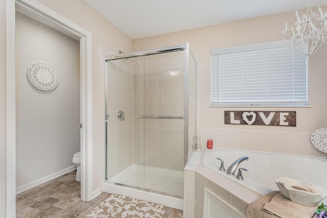 bathroom featuring baseboards, toilet, a bath, a shower stall, and a notable chandelier