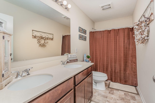 full bathroom with visible vents, double vanity, a sink, and toilet