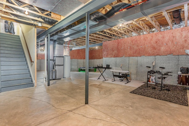 unfinished basement with water heater, brick wall, stairs, and heating unit