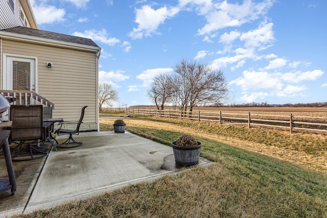 view of yard with a rural view, a patio area, and fence